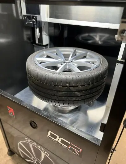 Technician inspecting damaged diamond cut alloy wheel
